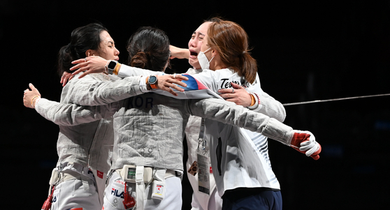 From left: Kim Ji-yeon, Seo Ji-yeon, Yoon Ji-su and Choi Soo-yeon celebrate after winning the women sabre team bronze medal at the Tokyo Olympics on Saturday at the Makuhari Messe Hall in Chiba, Japan. [JOINT PRESS CORPS]