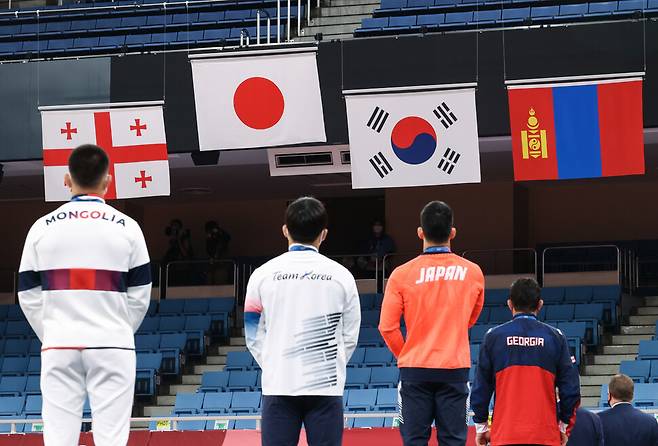 안창림(왼쪽 두 번째)이 26일 일본 도쿄 지요다구 무도관에서 열린 도쿄올림픽 유도 남자 73kg급 시상식에서 금메달을 딴 오노 쇼헤이의 일본 국가가 연주되는 동안 태극기를 바라보고 있다.연합뉴스.