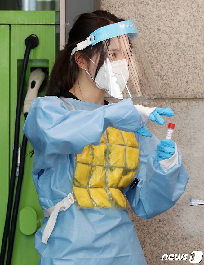 서울 동작구 보건소에 마련된 신종 코로나바이러스 감염증(코로나19) 선별진료소에서 의료진이 아이스팩 조끼를 입고 무더위를 극복하고 있다.© News1 민경석 기자