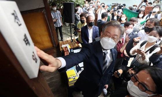 더불어민주당 대권 주자인 이재명 경기도지사가 지난달 30일 오전 대구 중구 남산동 전태일 열사 옛집을 찾아 지난해 11월 전태일 열사 50주기를 맞아 전태일의 친구들과 시민들이 달아놓은 문패를 어루만지고 있다. 뉴스1