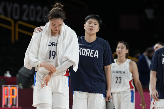 The Korean national basketball team players walk off the court after losing to Serbia 65-61 during a women's preliminary round basketball game at the 2020 Summer Olympics on Sunday in Saitama, Japan. [AP/YONHAP]