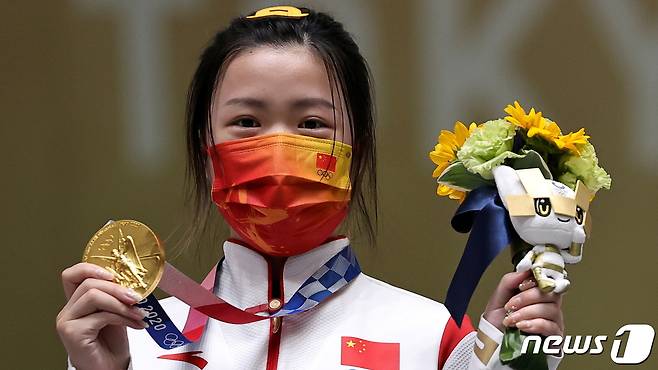 24일 도쿄 올림픽 첫 금메달리스트인 중국의 사격 선수 양치엔이 금메달을 들어 보이고 있다. © 로이터=뉴스1 © News1 박형기 기자