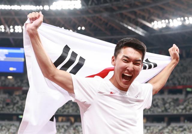 육상 국가대표 우상혁이 8월 1일 도쿄 올림픽스타디움에서 열린 2020 도쿄올림픽 남자 높이뛰기 결승전 경기에서 4위에 그쳤지만 한국신기록을 달성한 뒤 태극기를 들어보이고 있다. 도쿄=뉴시스