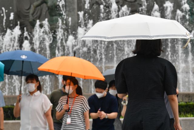 지난 2일 서울 중구 명동에서 시민들이 우산을 쓴 채 발걸음을 옮기고 있다. 이날 서울에선 흐리고 비가 내린 가운데 낮 최고기온 30도에 달하는 무더위가 이어졌다. 이한결 기자