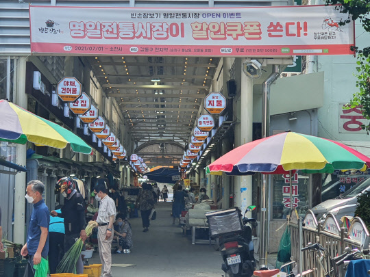 서울 강동구 명일시장에 빈손장보기 서비스를 소개하는 플래카드가 걸려 있다. <박상길 기자>