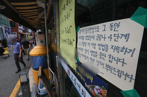 본격적인 휴가철을 맞은 4일 오후 점심시간 서울 종로구의 한 식당에 거리두기 격상 여파로 영업중단을 알리는 안내문이 붙어 있다. 뉴스1