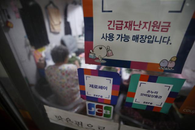 지난 2일 오후 서울 종로구 통인시장의 한 가게에 긴급재난지원금 사용 가능 안내문이 붙어 있다. 전 국민의 약 88%가 1인당 25만원씩 받는 5차 재난지원금의 구체적인 사용처 등은 이달 중순 확정된다. 연합뉴스