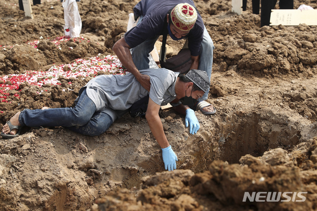[자카르타=AP/뉴시스] 지난달 7일(현지시간) 인도네시아 자카르타의 한 공동묘지에서 한 남성이 코로나19로 숨진 가족을 묻으며 오열하고 있다. 2021.08.04.