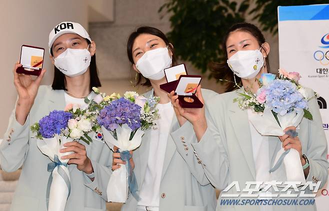 동료들이 배구협회에서 지급한 기념 메달을 들어보이고 있는 김연경.