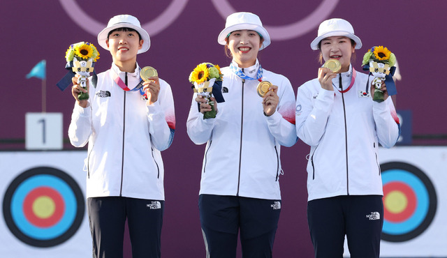 [도쿄(일본)=뉴시스] 최진석 기자 = 대한민국 양궁 대표팀 안산(왼쪽부터), 장민희, 강채영이 지난달 25일 오후 일본 도쿄 유메노시마 양궁장에서 열린 2020 도쿄올림픽 양궁 여자단체전 금메달을 획득, 시상식에서 시상대 올라 금메달과 트로피를 들어보이고있다. 2021.07.25. myjs@newsis.com