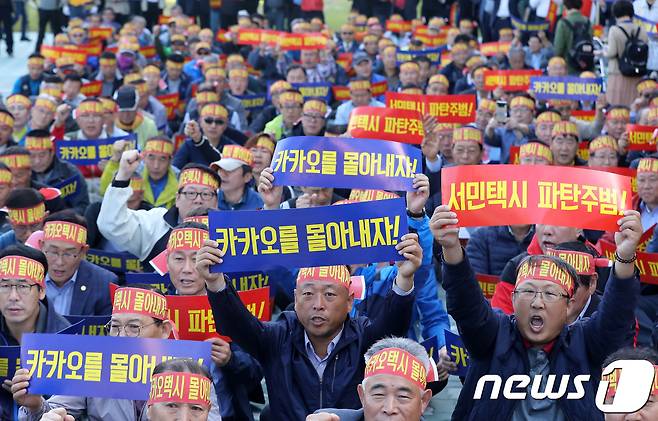 지난 2018년 10월 경기도 성남시 분당구 판교역 앞에서 열린 카카오 모빌리티 규탄 집회에서 수도권 전국택시노조, 전국민주택시노조, 전국택시운송사업조합 조합원들이 카카오 모빌리티의 승차 공유(카풀) 서비스 도입 추진을 반대하는 구호를 외치고 있다. 2018.10.4/뉴스1 © News1 오장환 기자