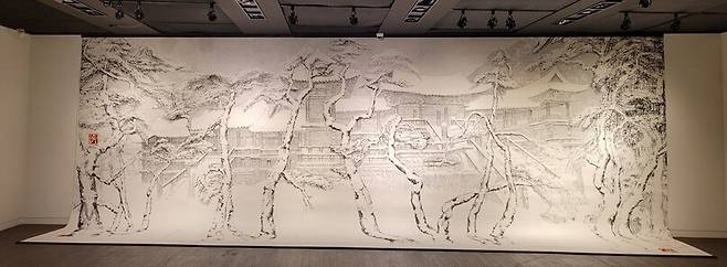 올해 그린 역작인 <불국설경>. 그의 전형적인 그림 소재인 경주 불국사의 눈 내린 모습을 담고 있다. 세로 약 2m에 가로 길이가 4m 넘는 대작이어서 전시장 1층에 벽면을 채우고 아랫부분은 늘어뜨린 모양새로 선보이고 있다.