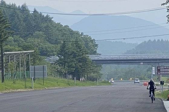 대관령 정상에서 바라본 평창군 횡계 방향. 오른쪽 자전거를 타고 가는 이는 현역 바이애슬론 국가대표 예카테리나 세르게예브나 아바쿠모바로, 체력 훈련을 위해 평창에서 대관령을 넘어 강릉을 찍은 뒤 다시 평창으로 넘어가고 있다. 김홍준 기자