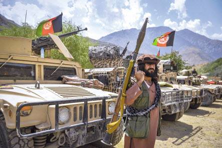 아프가니스탄 독립기념일인 19일(현지시간) 수도 카불에서 아프간 국기를 든 시민이 탈레반에 반대하는 시위를 벌이고 있다(위쪽). 19일(현지시간) 아프가니스탄 수도 카불 북동부 판지시르주(州)에 집결한 아프간 정부군의 모습. 현재 판지시르에 있는 반(反) 탈레반 세력의 병력은 2000~2500명으로 알려졌는데, 뉴욕포스트는 병력 규모를 6000명 이상으로 추산했다. [로이터·AFP]