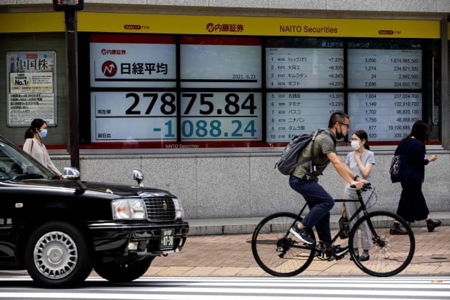 일본 도쿄증권거래소의 니케이지수가 적힌 전광판 앞을 지나는 시민들.(AFP 연합뉴스)