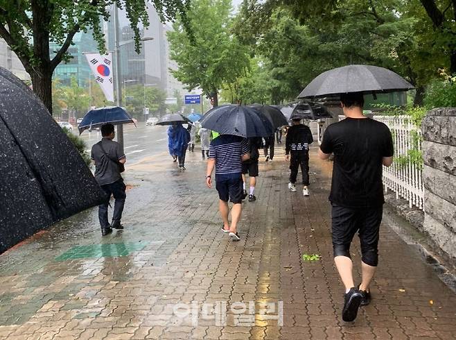 카카오톡 오픈 채팅방 등에서 자발적으로 모인 ‘소상공인걷기운동(가칭)’ 자영업자들이 21일 오후 폭우가 내리는 가운데 서울 여의도 국회의사당 앞에서 ‘1인 걷기 시위’를 펼치고 있다.(사진=독자 제공)