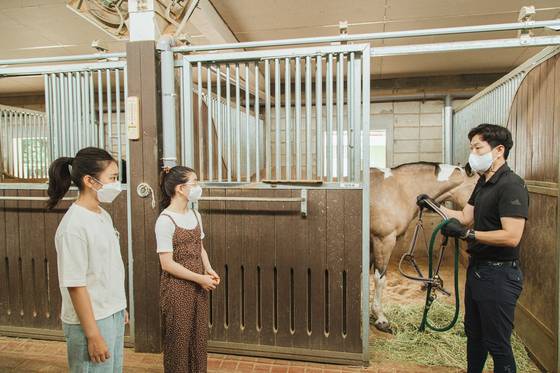박준형(오른쪽) 승마지도사가 소중 학생기자단에게 말을 대하는 법을 알려줬다. 말은 겁이 많아서 자신의 시야 밖인 뒤쪽에 사람이 서있는 걸 싫어한다.