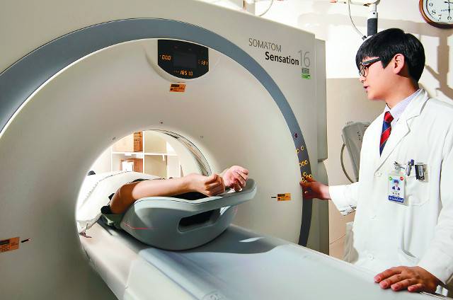 한 남성이 방사선사의 도움을 받아 흉부CT를 찍고 있다. 최근 건강검진을 통해 폐CT 영상에서 간유리 음영을 발견하는 사례가 늘고 있다. 강남세브란스병원 제공