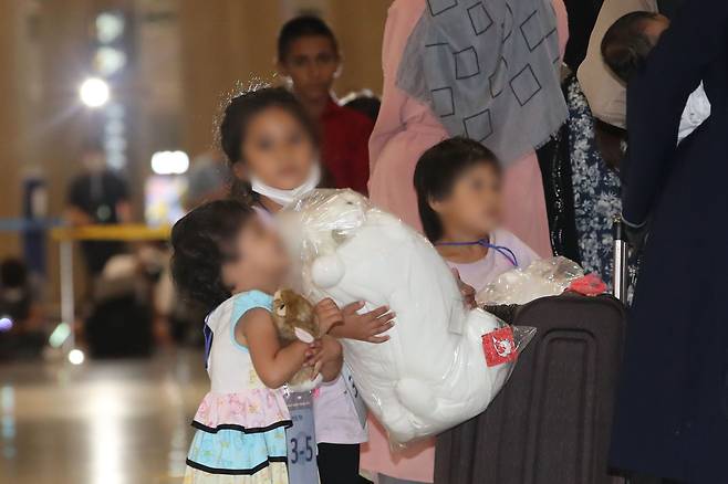 한국 정부와 협력한 아프간 현지 조력자 입국 대상 391명 중 378명이 입국한 26일 오후 인천국제공항 제1여객터미널에서 아프가니스탄 어린이들이 입국장을 빠져나가며 선물받은 인형을 들고 있다./뉴시스