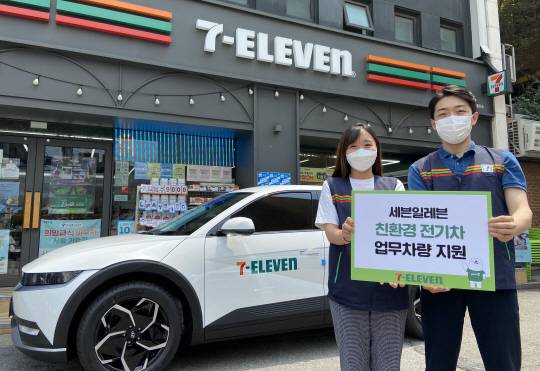 편의점 업체인 세븐일레븐 관계자들이 현장 직원들의 업무용 차량으로 제공된 친환경 전기차 앞에서 홍보 활동을 하고 있다.  롯데그룹 제공
