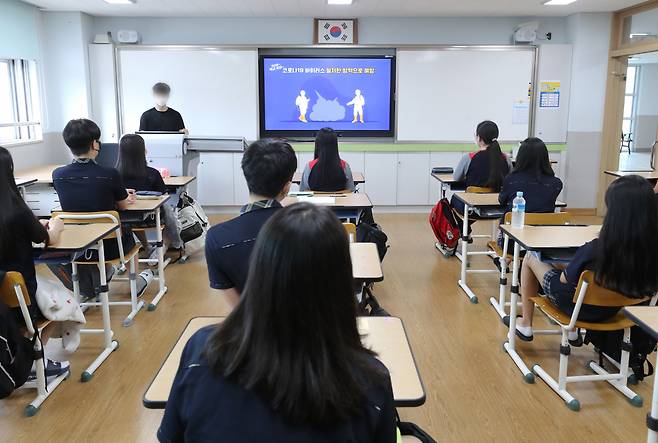 2학기 첫 등교를 시작한 지난 17일 오전 세종시에 있는 한 중학교에서 학생들이 수업에 앞서 코로나19 방역과 관련된 영상을 시청하고 있다. [연합]