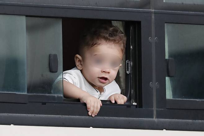 An Afghan child looks out the bus window on Friday. (Lee Jeong-a/The Hankyoreh)