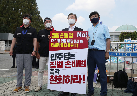 국민의힘 대선 주자인 최재형 전 감사원장이 10일 서울 여의도 국회 앞에서 허위 조작 보도에 징벌적 손해배상 적용을 내용으로 하는 언론중재법 개정안 반대 릴레이 시위 현장을 방문해서 반대 팻말을 들고 있다. [중앙포토]