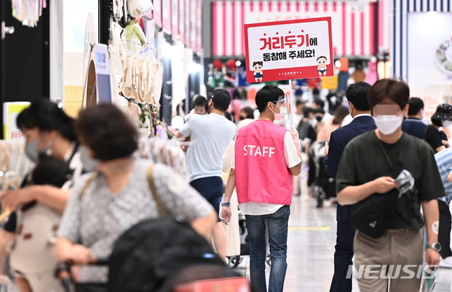 [수원=뉴시스] 김종택 기자 = 지난 27일 오후 경기도 수원시 권선구 수원메쎄에서 열린 '코베 베이비페어&유아교육전'에서 행사 관계자가 거리두기 동참을 알리는 안내판을 들고 있다. 2021.08.27. jtk@newsis.com