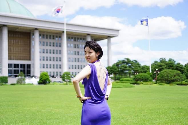 지난 6월 서울 여의도 국회 본청 앞 타투업법 제정 촉구 기자회견을 연 류호정 정의당 의원. 당시 타투 스티커를 한 등을 노출하기 위해 뒤쪽이 깊숙이 파진 보라색 드레스를 입고 사진을 찍는 퍼포먼스를 벌여 화제가 됐었다. /연합뉴스