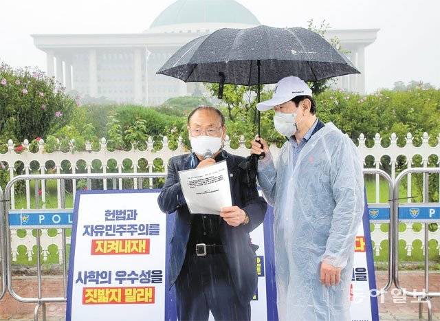 사립학교 교사 채용 시 1차 필기시험을 교육청에 의무 위탁하는 내용이 담긴 사립학교법 개정안이 31일 국회 본회의를 통과했다. 윤남훈 한국사립초중고등학교협의회장(왼쪽)은 이날 국회 정문 앞에서 열린 기자회견에서 “사학에 대한 조종이 울리고 있다”며 “사학 죽이는 사학법을 철폐하라”고 주장했다. 원대연 기자 yeon72@donga.com