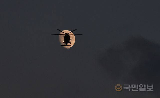 지난달 19일 인천 영종도 하늘에서 밝게 뜬 달 앞으로 해경 구조헬기가 순찰 비행을 하고 있다.