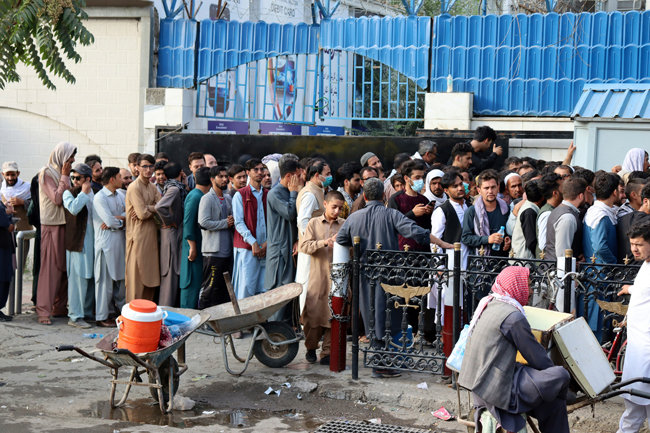 8월 30일(현지 시간) 아프가니스탄 수도 카불의 은행 앞에 현금을 찾으려는 시민들이 길게 줄을 서 있다. 탈레반이 아프간을 장악한 후 현금 인출 수요가 폭증하자 탈레반은 시민들의 인출 금액을 한 주에 200달러로 제한했다. [AP 뉴시스]