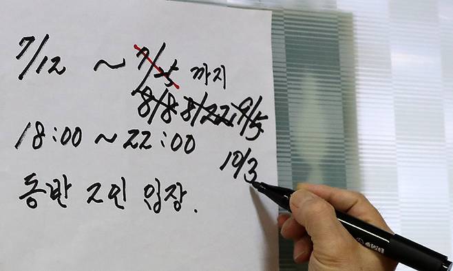 6일 서울시내 한 당구장에서 주인이 2인 입장 안내문을 수정하고 있다. 이날부터 식당·카페에는 백신 인센티브가 확대 적용되어 예방접종 완료자를 포함한 6인까지 모임이 가능하지만, 같은 다중이용시설 2그룹에 포함된 당구장을 비롯한 실내체육시설에는 적용되지 않는다. 뉴시스