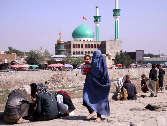 부르카로 전신 가리고 외출하는 아프간 여성 - 이슬람 무장세력 탈레반이 재장악한 아프가니스탄 수도 카불에서 4일(현지시간) 전신을 가린 부르카 차림의 한 여성이 아기를 안고 시내를 걸어가고 있다. 과거 탈레반 통치 시절(1996∼2001년) 여성들은 교육을 받거나 일할 기회를 빼앗기고, 부르카 없이는 외출이 불가능했으며 강제 결혼도 광범위하게 이뤄졌다. 카불 로이터 연합뉴스 2021-09-05