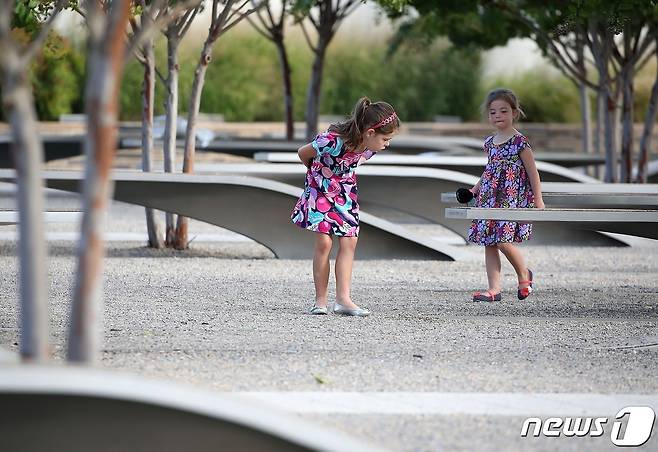 두 소녀가 앨링턴 소재 국방부 청사 펜타곤 주변에 마련된 911 추모 공원을 걷고 있다. 2016.09.11 © AFP=뉴스1