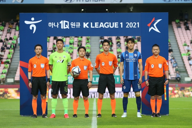 전북 현대 홍정호(왼쪽에서 두 번째)와 울산 현대 원두재(왼쪽에서 다섯 번째)가 5월 19일 전주월드컵경기장에서 열린 2021 하나원큐 K리그1 경기 시작 전 심판진과 함께 사진을 찍고 있다.  한국프로축구연맹 제공