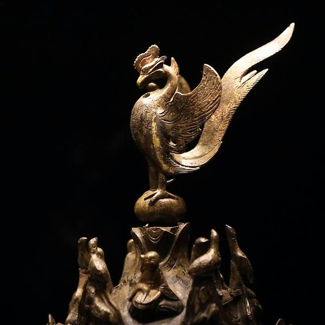 A Phoenix sits on top of the Gilt-bronze Incense Burner of Baekje, Korea’s National Treasure No. 287. The incense burner clearly features animals from distant places, not indigenous to Korea, testifying to the far reaches of the Baekje Empire’s maritime presence and the empire’s 22 “damro” vassal states.　Photo © 2020 Hyungwon Kang