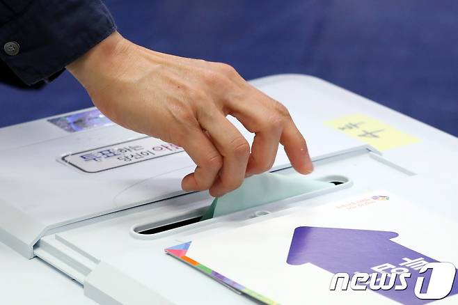 제7회 전국동시지방선거 투표일인 2018년 6월13일 서울 서초구 원명초에 마련된 투표소에서 한 시민이 투표함에 기표용지를 넣고 있다. /뉴스1 © News1 박지수 기자