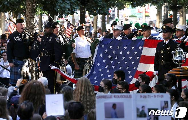 뉴욕 경찰 백파이프 팀이 2021년 9월 11일(현지시간) 미국 뉴욕시의 세계무역센터 부지에서 열린 2001년 9월 11일 테러 공격 20주년 기념식에서 세계무역센터의 미국 국기를 들고 서 있다. © 로이터=뉴스1 © News1 김현 특파원