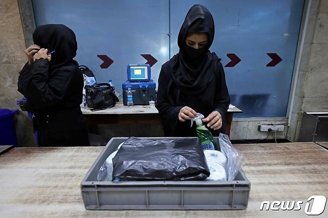 카불 공항 검색대에서 2021년 9월 12일 업무에 복귀한 여성 직원이 근무하는 모습. 카불 공항에는 80여 명의 여성 직원이 근무해왔지만, 지난달 15일 탈레반이 카불을 장악한 이후 지금까지 업무에 복귀한 여성 직원은 12명에 그친다. © AFP=뉴스1 © News1 최서윤 기자