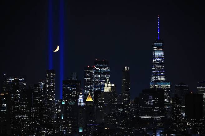 미국이 9.11 테러 20주년을 맞은 가운데 뉴욕 맨해튼에서 11일 세계무역센터 쌍둥이 빌딩을 상징하는 파란 빛 두 줄기가 하늘로 쏘아올려지는 '트리뷰트 인 라이트'가 열리고 있다. /AFP 연합뉴스
