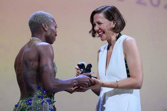 미국 배우 매기 질렌할(오른쪽)은 첫 장편 연출작 '더 로스트 도터'로 은사자상-각본상을 받았다. 질렌할은 수상 소감에서 “(원작 소설을 읽고) 고등학교 때 제인 캠피온 감독의 영화 ‘피아노’를 봤을 때랑 같은 감정을 느꼈다”면서 “작가로서의 내 삶과 내 영화는 여기 이 극장에서 태어났다”고 말했다. [AFP=연합뉴스]