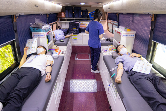 방문규(오른쪽) 수출입은행장이 지난 10일 서울 여의도 본점에서 이동 헌혈버스를 활용해 단체 헌혈에 참여하고 있다./사진 제공-수출입은행