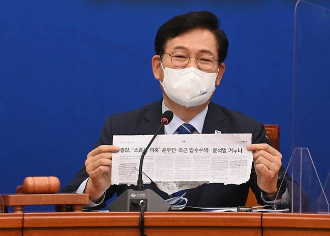 송영길 더불어민주당  대표가 13일 오전 국회에서 열린 최고위원회의에서 윤석열 전 검찰총장 부인과 측근에 대한 검찰 수사 기사를 들어보이며 발언하고 있다. 공동취재사진