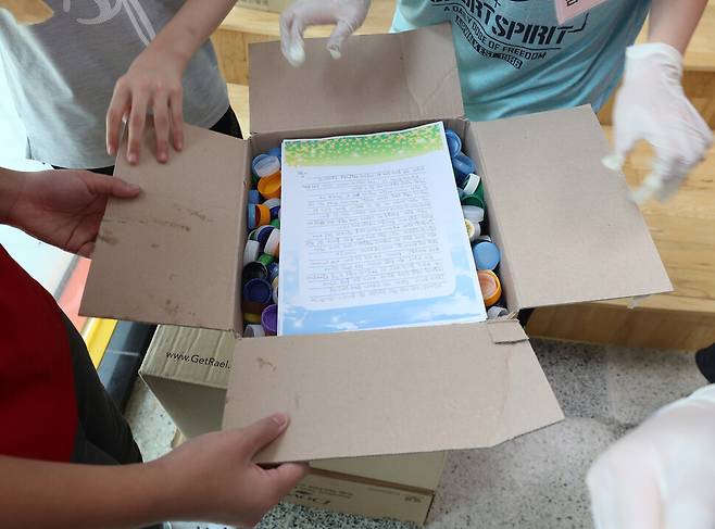 나눔초 학생들이 지난 4~7월 한 학기 동안 모은 병뚜껑 고리를 모아 종이상자에 담고 있다. 강창광 선임기자 chang@hani.co.kr