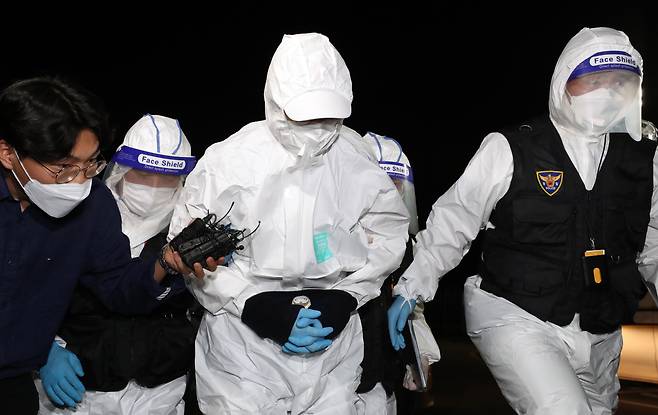 해외로 도피했다가 석달만에 귀국한 문흥식 전 5·18구속부상자회장이 11일 오후 광주서부경찰서로 압송되고 있다. 문씨는 철거 건물 붕괴 참사가 발생한 광주 학동4구역 재개발 사업 업체 선정 과정에서 금품을 받은 혐의로 체포됐다. /연합뉴스