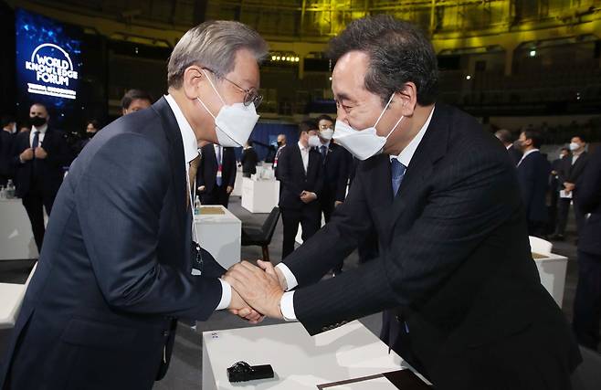 14일 서울 중구 장충체육관에서 열린 제22회 세계지식포럼 개막식에 참석한 이재명(왼쪽), 이낙연 더불어민주당 대선 경선 후보가 인사하고 있다. /뉴시스