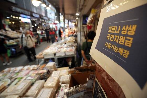 서울 동대문구 청량리 종합시장 내 한 가게에 신종 코로나바이러스 감염증(코로나19) 상생 국민지원금 사용 가능 매장이라고 적힌 안내문이 붙어 있다. 연합뉴스