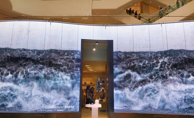 지난달 20일 경기도 화성시 롯데백화점 동탄점 명품관 외벽에 디지털 미디어 콘텐츠 제작사인 디스트릭트의 작품이 전시돼 있다. 디지털 기술로 공간의 혁신을 추구하는 이 업체는   지난 7월 미국 뉴욕 타임스스퀘어 전광판에 초대형 폭포와 파도로 만들어진 고래 형상의 미디어 아트 영상을 전시해 화제를 모았다.