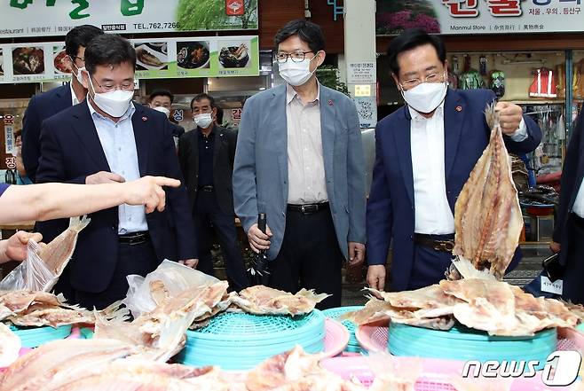 좌남수 제주도의회 의장(사진 오른쪽)이 지난 14일 추석 맞이 민심 탐방의 일환으로 서귀포매일올레시장을 방문해 건어물을 들어보이고 있다.(제주도의회 제공)2021.9.15/뉴스1